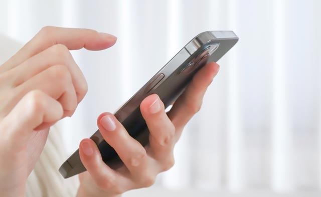 家族葬の大和市葬儀社に電話でお問合せしようとしている人の手元。